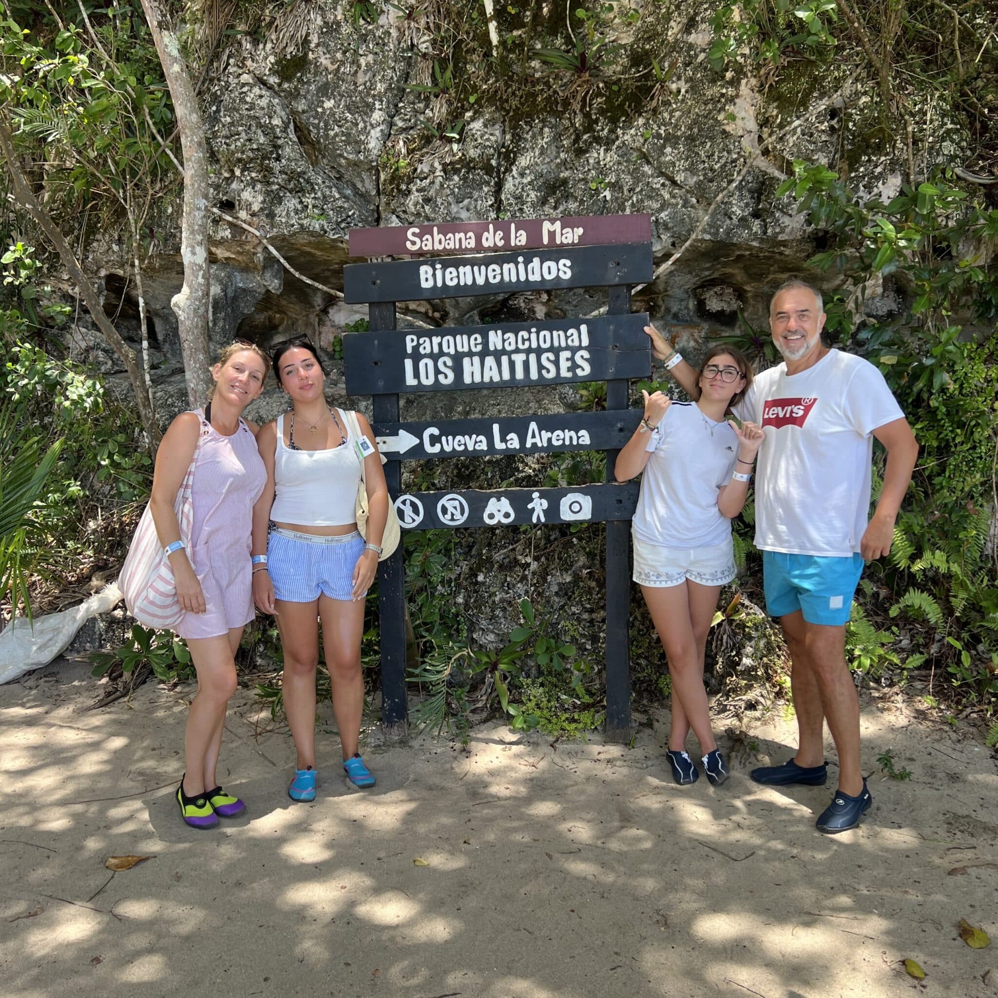 Family posing for a photo next to the directions point