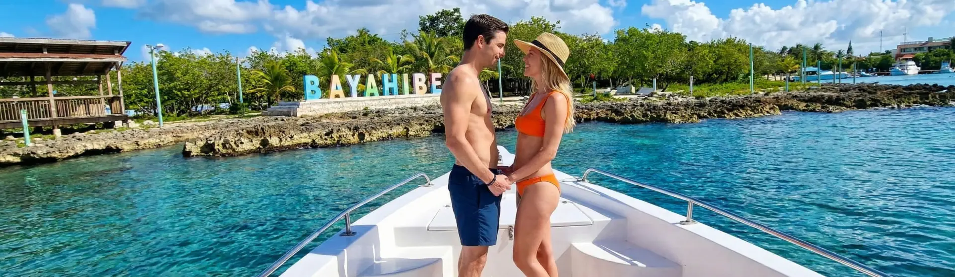 Couple gazing romantically in front of the Bayahibe sign